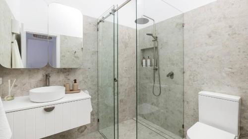 une salle de bain avec une douche en verre et un lavabo dans l'établissement Solace by the Bay, à Corlette