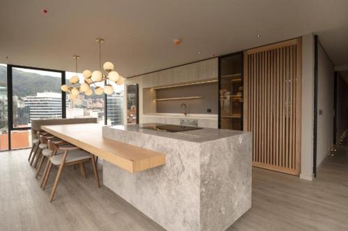 a kitchen with a large concrete counter and a table at Apartamento in Bogotá