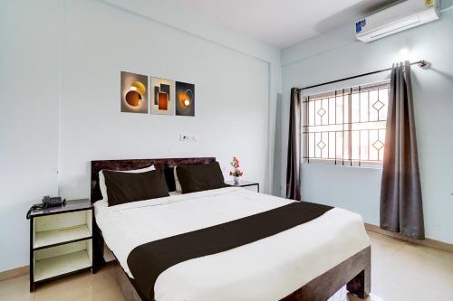 a bedroom with a large bed and a window at Super Collection O Uttarahalli in Bengaluru