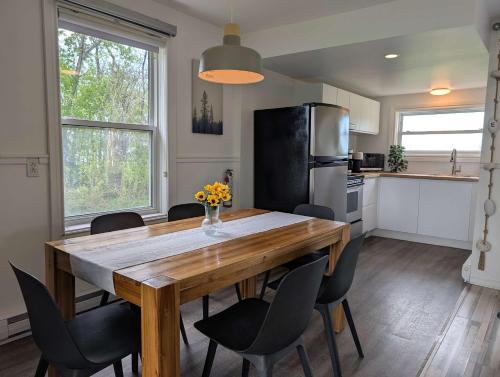a kitchen with a wooden table and a refrigerator at Condo 1 - Waterfront with SPA Fireplace & Barbecue in Sainte-Anne-de-Beaupré