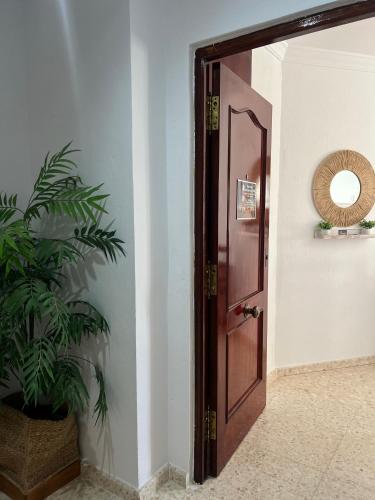 a wooden door in a hallway with a potted plant at Apartamento El Faro in Barbate
