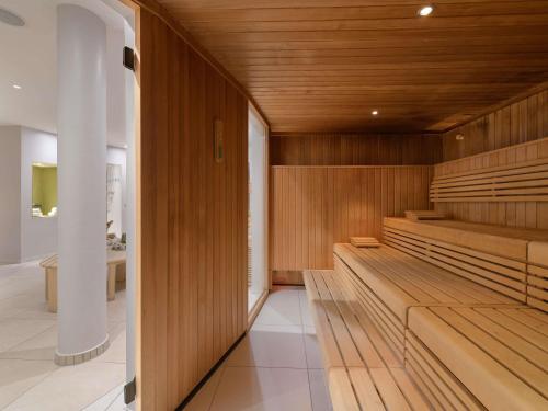 a sauna with wooden benches in a room at Pullman Munich in Munich