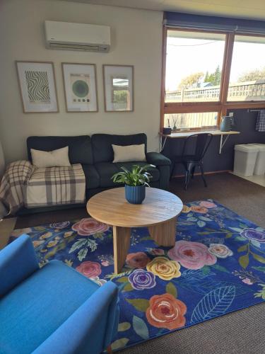 een woonkamer met een bank en een tafel bij McKerrow St - 2 in Te Anau