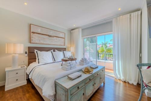 Un dormitorio con una cama grande y una ventana grande. en 5 star Luxury Palmview apartment with large terrace and communal pool, en Quarteira