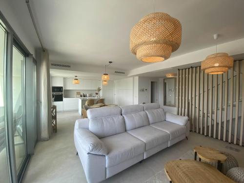 a living room with a white couch and a kitchen at Eden Deluxe, Jacuzzi & Sea in Mijas Costa