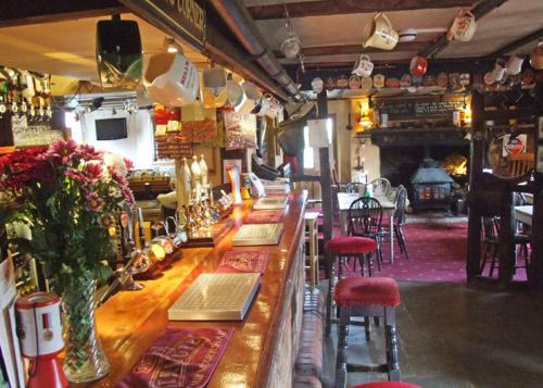 a bar in a restaurant with red stools at The White Horse Inn in Washford