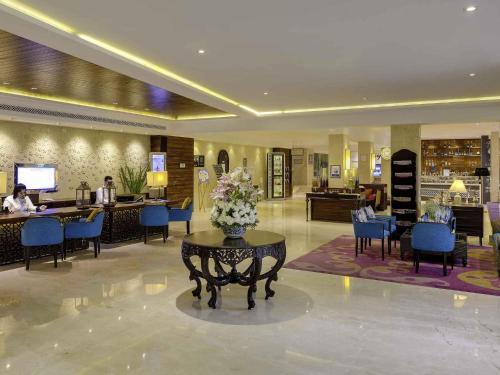 a lobby with a table with a vase of flowers on it at Novotel Goa Resort & Spa Candolim in Candolim