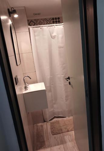 a white bathroom with a shower and a sink at Departamento 9 de Julio Temperley in Turdera