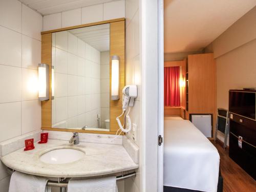 a bathroom with a sink and a large mirror at ibis Recife Boa Viagem in Recife