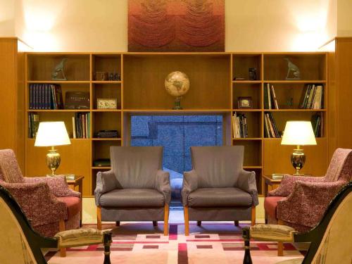 a living room with two chairs and a fireplace at The Cypress Mercure Hotel Nagoya in Nagoya