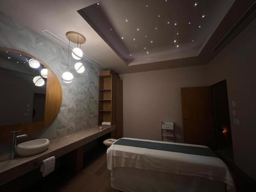 une salle de bain avec un lit, un lavabo et un miroir dans l'établissement GR Solaris Caribe - All Inclusive, à Cancún