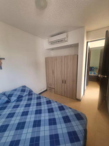 a bedroom with a blue bed and wooden cabinets at Ciudadela Santafe in Santa Fe de Antioquia