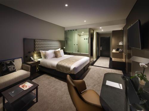a hotel room with a bed and a couch at Pullman Brisbane Airport in Brisbane
