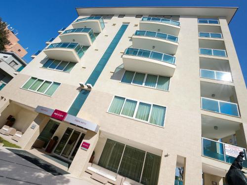 un grand bâtiment avec des balcons sur le côté dans l'établissement Mercure Hotel Rimini Artis, à Rimini