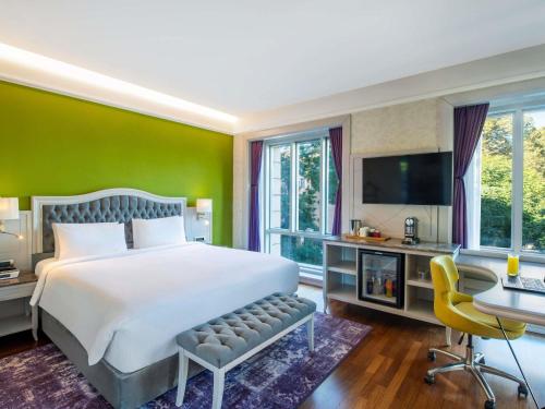 トビリシにあるMercure Tbilisi Old Townのベッド、机、テレビのある寝室