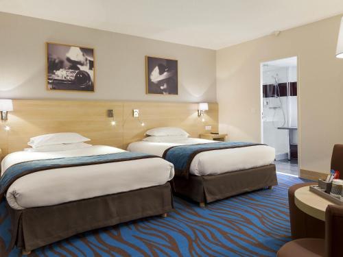 a hotel room with two beds in a room at Mercure Paris 19 Philharmonie La Villette in Paris