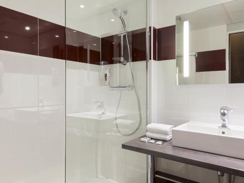 a white bathroom with a shower and a sink at Mercure Paris 19 Philharmonie La Villette in Paris