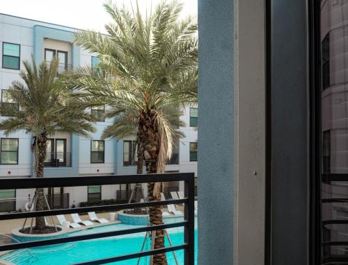 a view of a palm tree from the balcony of a hotel at New! The Vibe Med Center Apartments - Central Houston in Houston