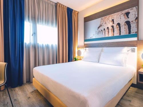 a hotel room with a large bed and a window at Mercure Roma Centro Colosseo in Rome