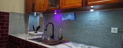 a bathroom with a sink and a mirror at Rockville Building Studio Meuble Guest House in Yaoundé