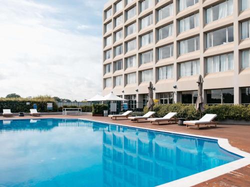 a hotel swimming pool in front of a building at Mercure Sydney Parramatta in Sydney
