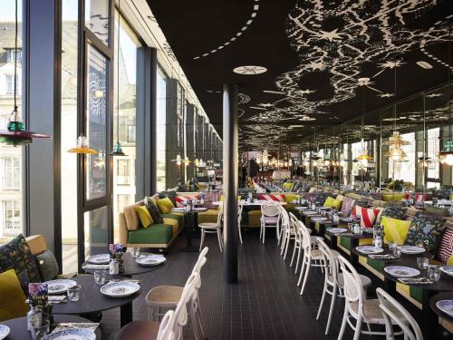 a restaurant with many tables and chairs and windows at Mama Shelter Rennes in Rennes