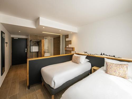 two beds in a hotel room with at Mercure Avignon Gare TGV in Avignon