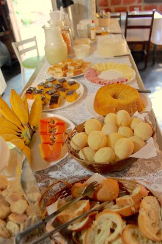 西波山Pousada Bangalôs Cipó的长桌,长桌里放着不同种类的食物