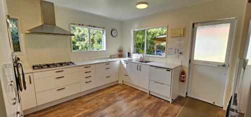 PakawauにあるSoggy Bottom Farm House, Sea views and peacocksのキッチン(白いキャビネット、白い電化製品付)