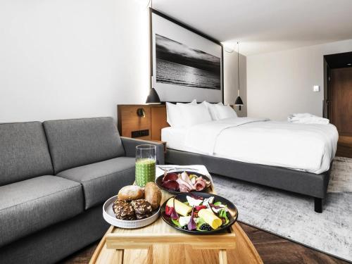 a hotel room with a couch and a bed at MERCURE KLAIPEDA CITY HOTEL, Meetings, Events, Restaurant & Bar - Accor Group, Pet Stay FREE in Klaipėda