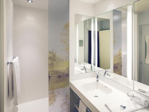 マコンにあるHôtel Mercure Mâcon Bord de Saôneの洗面台が2つと大きな鏡があるバスルーム