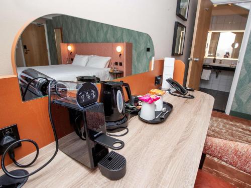 a room with a room with a bed and a desk at Mercure Thurrock Stifford Hall in Grays Thurrock
