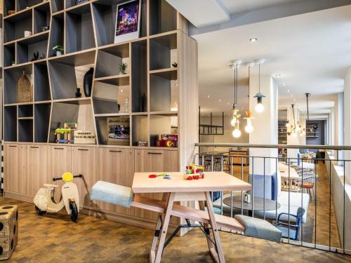 a kitchen with a table and a dining room at Aparthotel Adagio access Hamburg in Hamburg