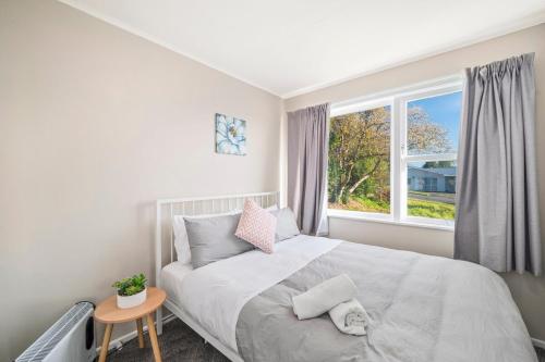 a bedroom with a bed and a window at 5 Bedrooms Lake View Cosy Place in Rotorua