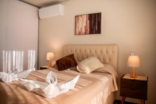 ein Schlafzimmer mit einem Bett mit weißen Laken und Kissen in der Unterkunft Vertical 60 in Santa Cruz de la Sierra