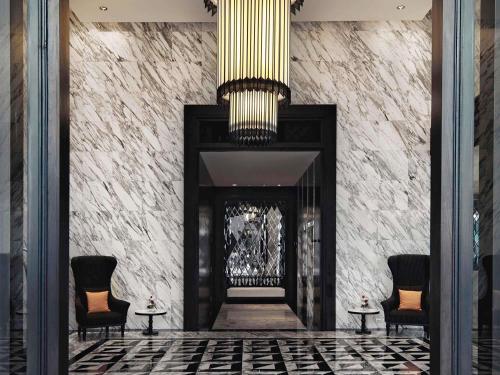 vestíbulo con chimenea y lámpara de araña en Mövenpick Hotel Sukhumvit 15 Bangkok, en Bangkok