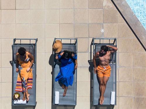 grupa mężczyzn na łóżkach piętrowych przy basenie w obiekcie Mercure Maceio Pajuçara w mieście Maceió