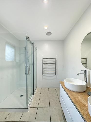 a bathroom with a glass shower and a sink at Conifer Grove Family Oasis 5BR Sleeps 10 Amazing Seaview in Auckland