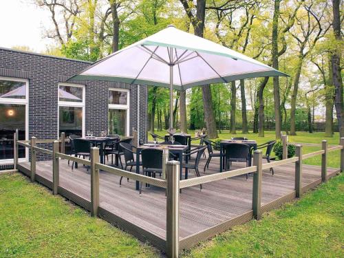 a deck with tables and chairs and an umbrella at Mercure Hotel am Entenfang Hannover in Hannover