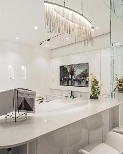 a white kitchen with a white counter and a chandelier at EasyStay Apartments in Ogere