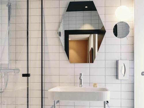 a bathroom with a sink and a mirror at Mercure Marseille Canebière Vieux-Port in Marseille