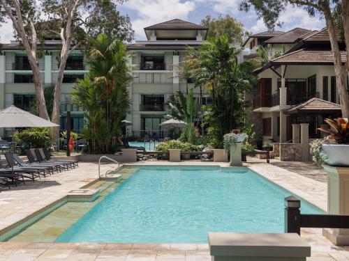 a swimming pool in front of a building at Pullman Palm Cove Sea Temple Resort & Spa in Palm Cove