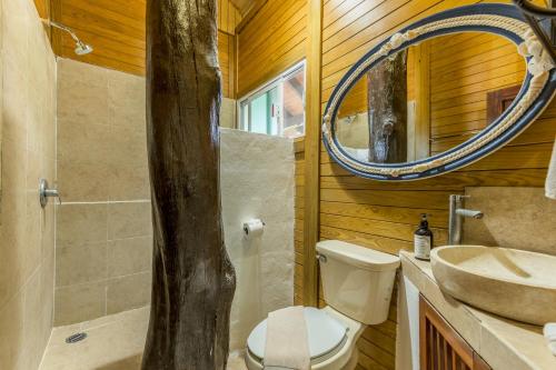 ein Badezimmer mit Toilette, Waschbecken und Spiegel in der Unterkunft Tekio Beach Hotel in Holbox