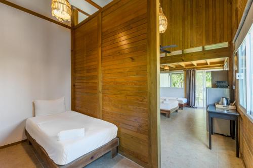 ein Schlafzimmer mit einem Bett und einer Holzwand in der Unterkunft Tekio Beach Hotel in Holbox