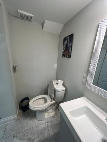 a white bathroom with a toilet and a sink at Basement in Brampton