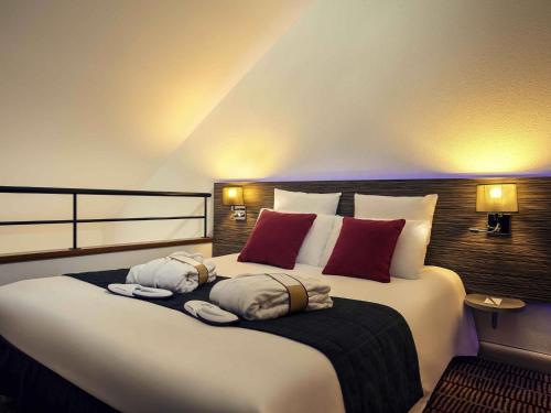 a bedroom with a large bed with towels on it at Hotel Mercure Blois Centre in Blois