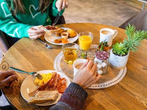 un grupo de personas sentadas en una mesa desayunando en ibis Bordeaux Pessac Route des Vins, en Pessac