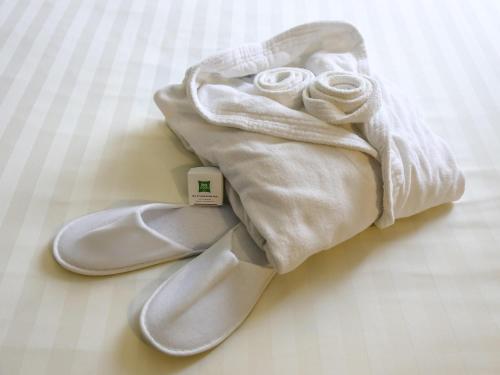 a pair of white shoes and a towel at Ibis Styles Roma Eur in Rome