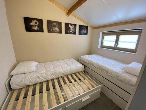 Dormitorio pequeño con 2 camas y cuadros en la pared en Westhinder II H8, en Witte Burg