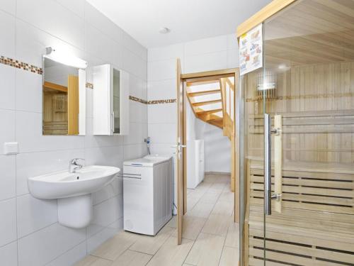 a white bathroom with a sink and a toilet at Stranddistel links mit Sauna in Boiensdorf